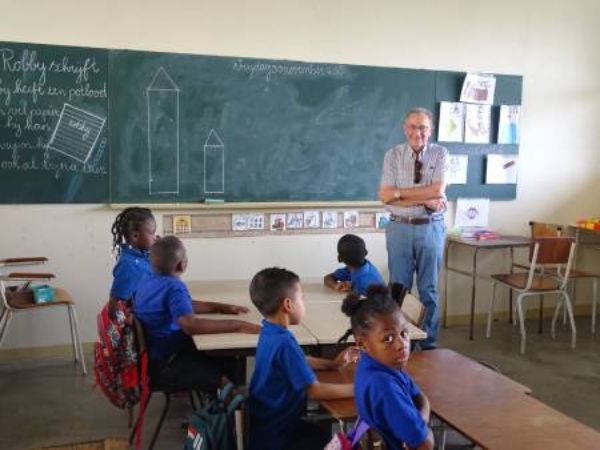 Donateur Nick staand voor de klas in Suriname